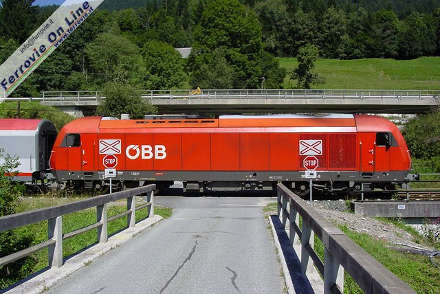 Se si escludono quelli posti sulle arterie principali, tutti i passaggi a livello sono privi di sbarre e di segnali luminosi. Lato strada segnali di Stop e Croci di S. Andrea avvisano che bisogna fermarsi ed accertarsi che non arrivi il treno. Il Regionale 4812 Kötschach-Mauthen - Villach HBF sta svolgendo servizio viaggiatori a Watschig, con la moderna Hercules 2016 che impegna il vicino passaggio a livello.