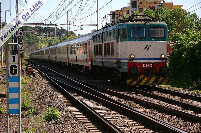 Anche il secondo treno che riporta in patria i pellegrini francesi, questo composto in gran parte da vetture con cuccette belghe (SNCB), si lascia alle spalle la Capitale e fa rotta verso la Francia. Lo vediamo sempre a Settebagni, dietro l'E.656.040.